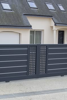 a house with two garage doors and a black fence