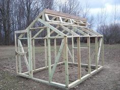 a small wooden structure sitting in the middle of a field