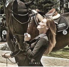 a woman standing next to a brown horse