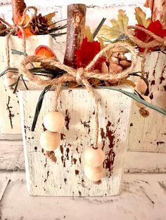 two white wooden boxes with fall decorations on them