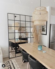 a dining room table with chairs and a light hanging from the ceiling in front of it