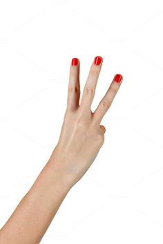 a woman's hand with red nail polish holding an object in the air