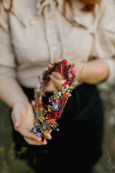 a woman holding a flower crown in her hands