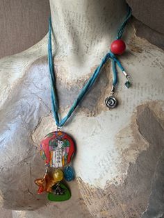 a mannequin wearing a necklace with an image of jesus and other items on it