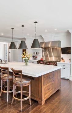 a large kitchen with an island in the middle and lots of stools around it