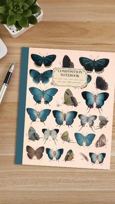 a notebook with butterflies on it next to a pen