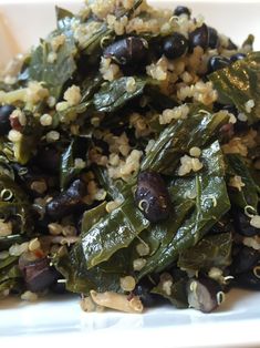 a white plate topped with black beans and greens