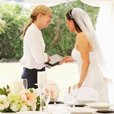 the bride and groom are exchanging their wedding vows at the dinner table with white linens