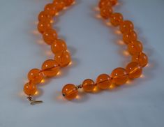 "Vintage c1950's tangerine orange clear lucite bead necklace Excellent condition 1/2\" diameter bead, except for the bead adjacent to the clasp bead, those are 3/8\" diameter and 1/4\" diameter The clasp bead is 1/2\" 26 inches long" Vintage Orange Beaded Necklaces For Formal Occasions, Vintage Orange Jewelry With Faceted Beads, Orange Vintage Jewelry With Faceted Beads, Formal Orange Single Strand Necklace, Vintage Orange Round Beads Necklace, Vintage Orange Round Bead Necklace, Vintage Orange Necklace With Round Beads, Vintage Orange Necklace With Large Beads, Vintage Large Orange Beads