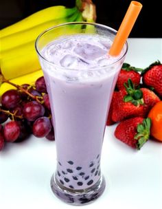 a glass filled with fruit and milk next to bananas