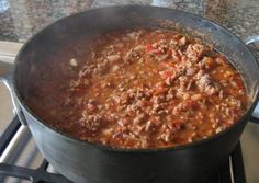 a pot filled with chili sitting on top of a stove