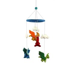 a baby crib mobile with three colorful birds hanging from it's sides and clouds in the background