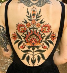 the back of a woman's body with tattoos on it