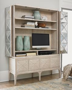 a living room filled with furniture and a flat screen tv sitting on top of a wooden shelf