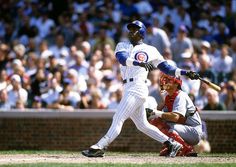 a baseball player is swinging his bat at the ball while people watch from the stands