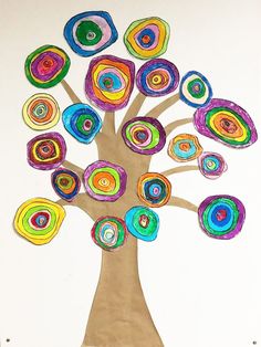 an art project made with colored paper and circles on a white background, depicting a tree