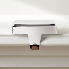 a close up of a metal object on a window sill with white paint and black trim