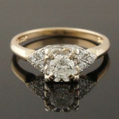 an old mine cut diamond ring with three stones on the band and two diamonds in the middle