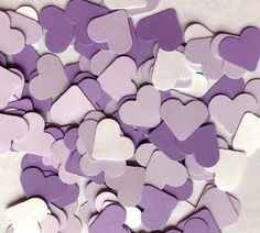 purple and white paper hearts are scattered together