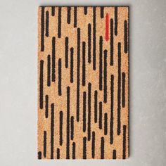 a cork board with black and red lines painted on the front, against a gray wall