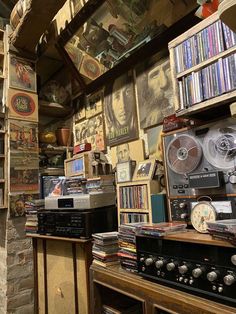 a room filled with lots of different types of audio equipment and bookshelves full of cds