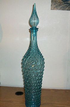 a blue glass vase sitting on top of a wooden table