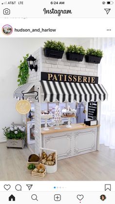 a pastry shop with white brick walls and black and white awning