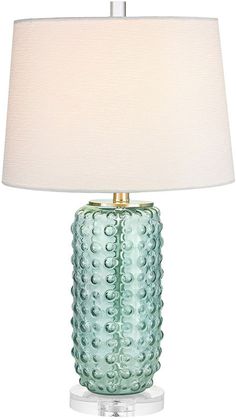 a green glass table lamp with a white shade