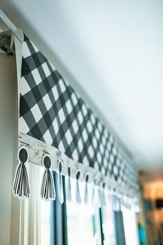 a window curtain with tassels hanging from it's side in front of a window