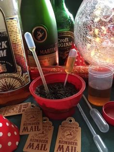 some bottles and cups on a table with paper tags, spoons and other items