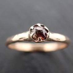 a gold ring with a brown diamond in it