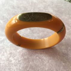 Awesome Vintage Bakelite Bangle Bracelet, Butterscotch color with beautiful original brass banding and oval brass plates. These plates could be monogrammed. Some minor scratching on the plates, could be polished out, I will leave that to the new owner. Standard 2.5 inch opening, the bracelet is almost 1/2 inch wide at the thickest part the oval brass plate is 1.5 X 0.5 inches. The bracelet is 3/4 inch wide. This is in beautiful vintage condition, see all photos. Very unusual to find one like thi Vintage Bangle With Polished Finish, Adjustable Oval Bangle With Polished Finish, Vintage Orange Bangle Bracelets, Retro Adjustable Gold Bangle, Adjustable Retro Gold Bangle, Vintage Bangle Bracelet With Polished Finish, Vintage Bangle Bracelets With Polished Finish, Adjustable Gold Oval Cuff Bracelet, Adjustable Oval Gold Cuff Bracelet