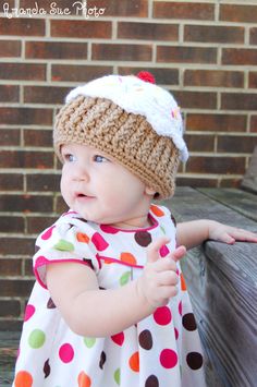 a baby girl wearing a knitted hat and dress