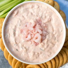 a bowl of dip surrounded by crackers and celery