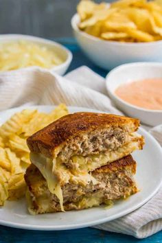 a sandwich cut in half on a plate with chips