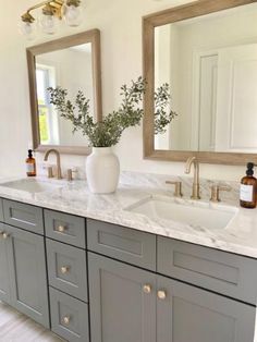 a bathroom with double sinks and two mirrors