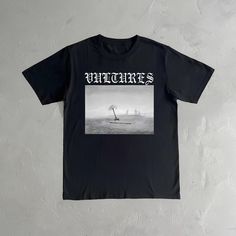 a black t - shirt with an image of sailboats in the ocean on it