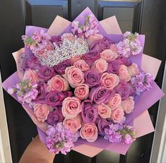 a bouquet of pink roses and purple flowers