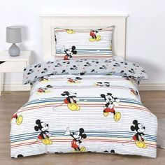 mickey mouse bedding set with striped sheets and pillowcases on wooden flooring