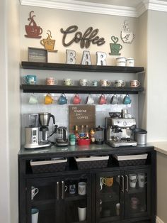 the coffee bar has many different types of cups on it and is decorated with metal letters