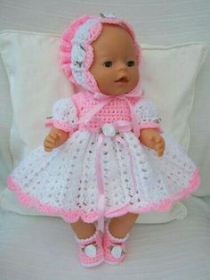 a baby doll wearing a pink and white crochet dress