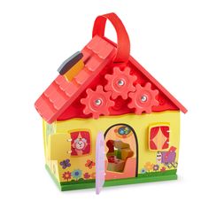 a small toy house with lots of toys on top of it and a pencil sticking out of the door