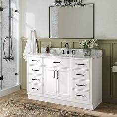 a white bathroom vanity with two sinks and a large mirror above it on the wall