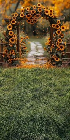 an arch made out of sunflowers in the grass