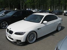 a white car parked in a parking lot next to other cars