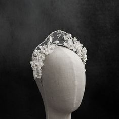 a white headpiece with flowers on it's side is shown in black and white