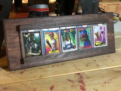 a wooden frame with four baseball cards in it on a table next to other items