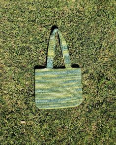 a green and blue bag sitting on top of grass