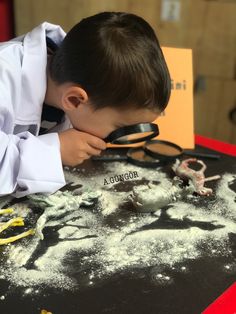 a young boy looking through a pair of magnifying glasses at snow covered ground