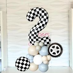 the number two balloon is decorated with black and white checkered balloons, which are hanging from a ceiling